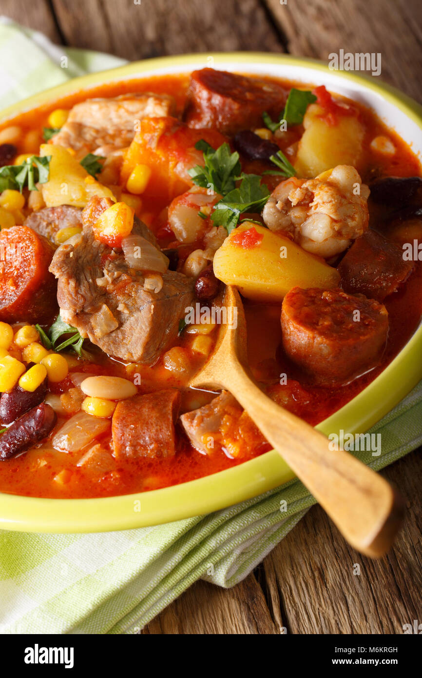 National cuisine of Cape Verde: Cachupa with meat, chorizo and vegetables close-up on a plate on a table. vertical Stock Photo