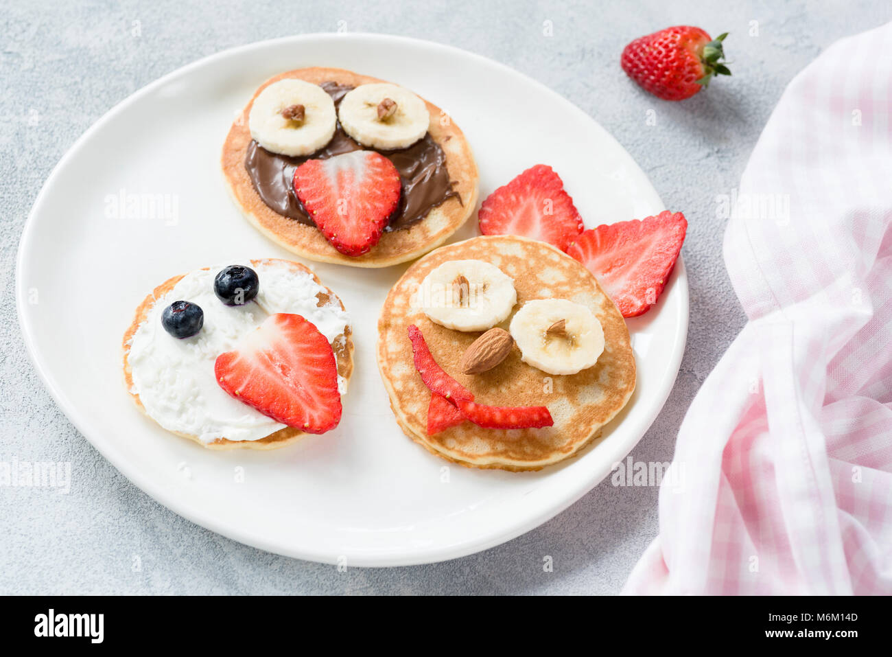 Pancakes art for kids on white plate. Colorful kids meal. Healthy