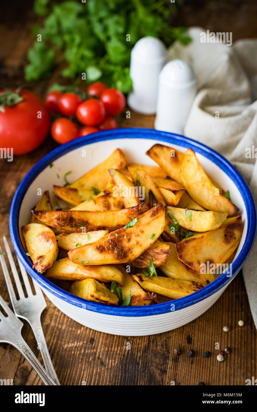 Roasted potato wedges in dinner bowl. Snack, appetizer or side dish. Selective focus Stock Photo