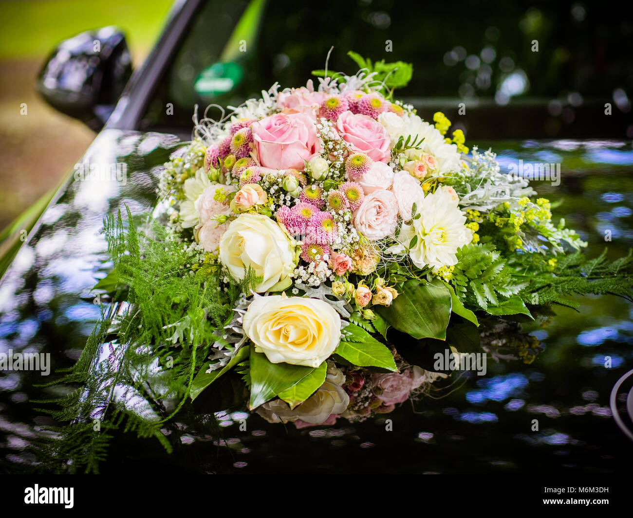 Wedding bouquet on the hood of a black retro car Stock Photo