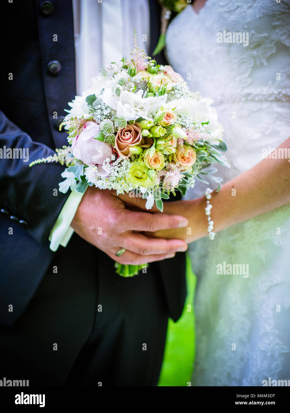 Bride with groom holding wedding bouquet at ceremony Stock Photo - Alamy
