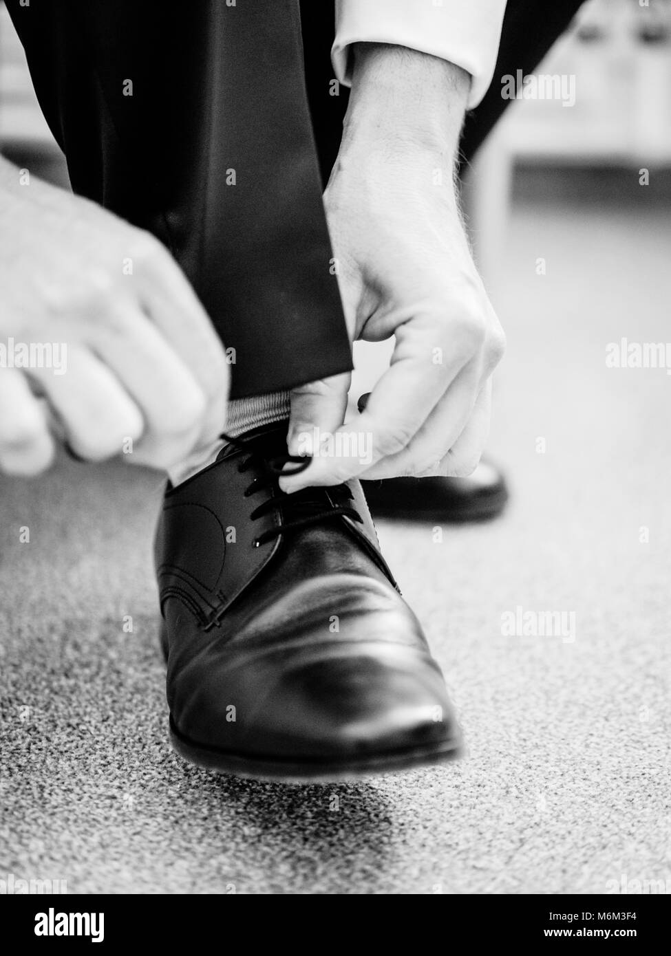Business man dressing up with classic elegant shoes groom wearing shoes on wedding day tying the Stock Photo