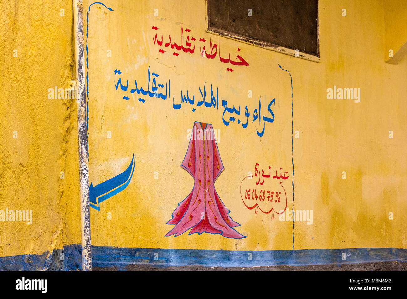 A colourful painted advert on a wall in the Muslim Quarter of Res, Morocco Stock Photo