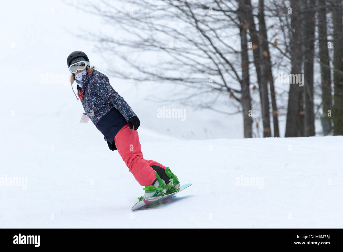 Female snowboarder on ski slope Stock Photo