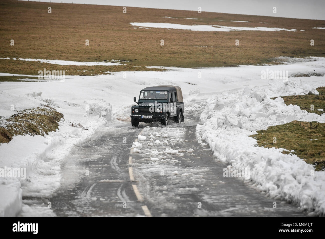 A 4x4 vehicle travels along a recently cleared section of the A39 at Porlock Hill, near Lynton, Exmoor, after heavy snow drifts affected the area and cut off Lynton Village. Stock Photo
