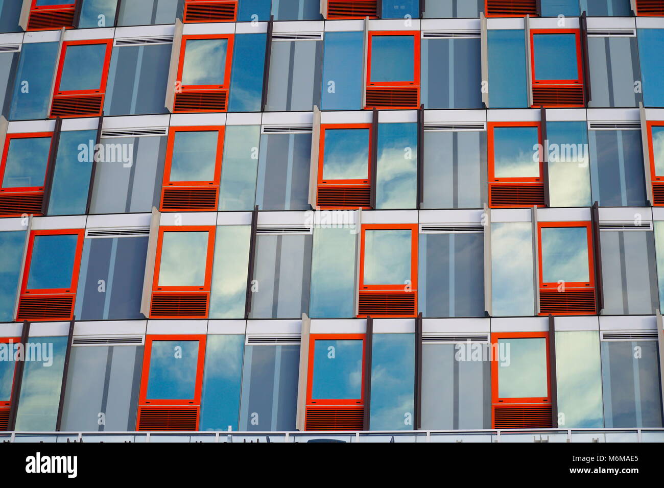 Red outline window pattern with reflecting windows of a cloudy blue sky ...