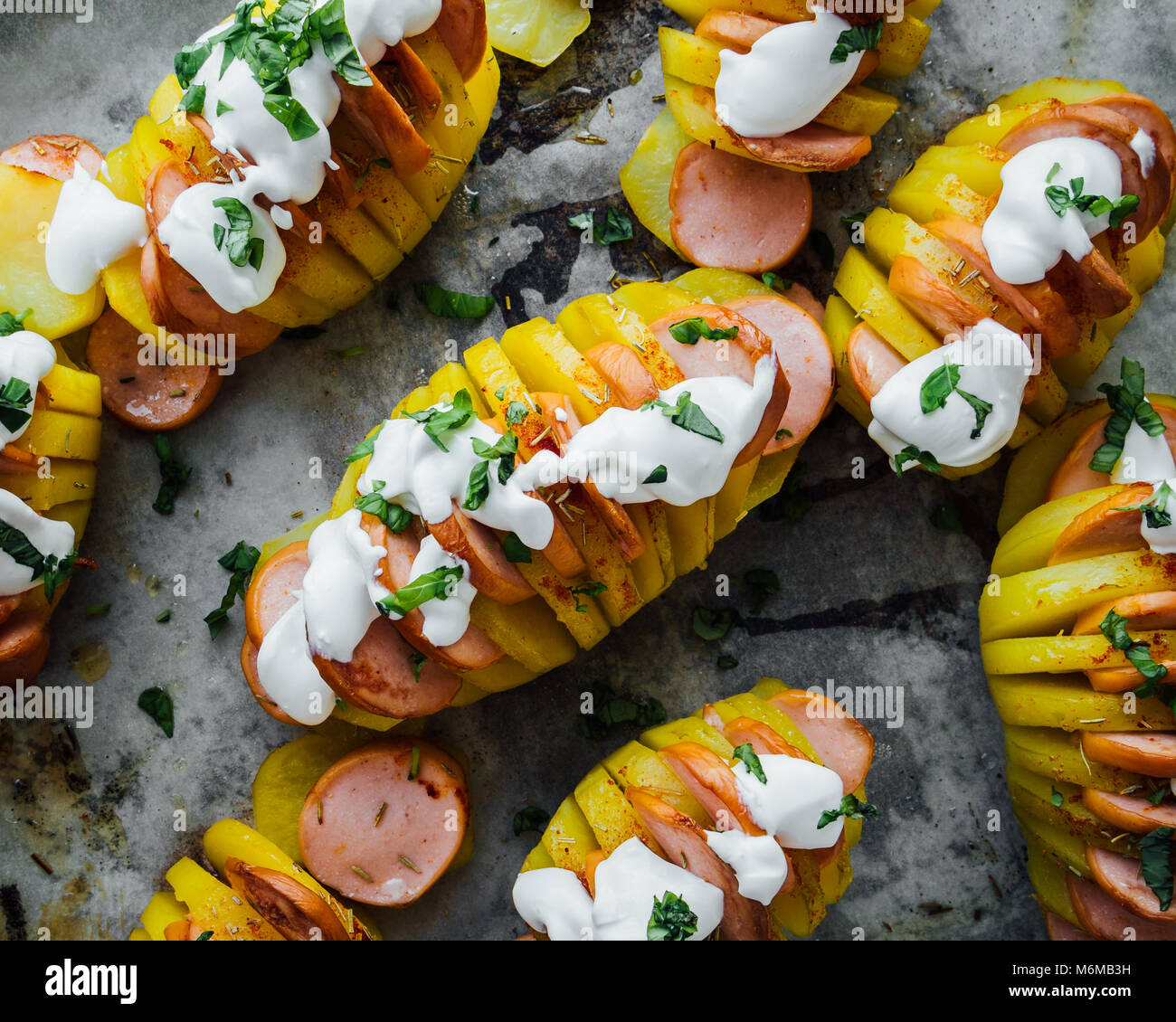 Baked hasselback potatoes with sausage and cream Stock Photo Alamy