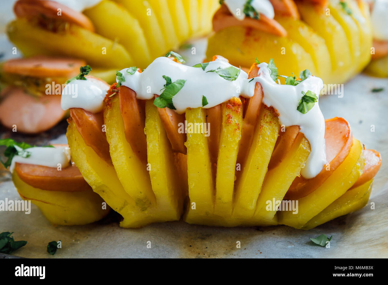 Baked hasselback potatoes with sausage and cream Stock Photo Alamy