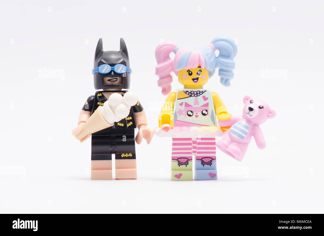 lego batman holding ice cream and n-pop girl holding a teddy bear isolated  on white background Stock Photo - Alamy