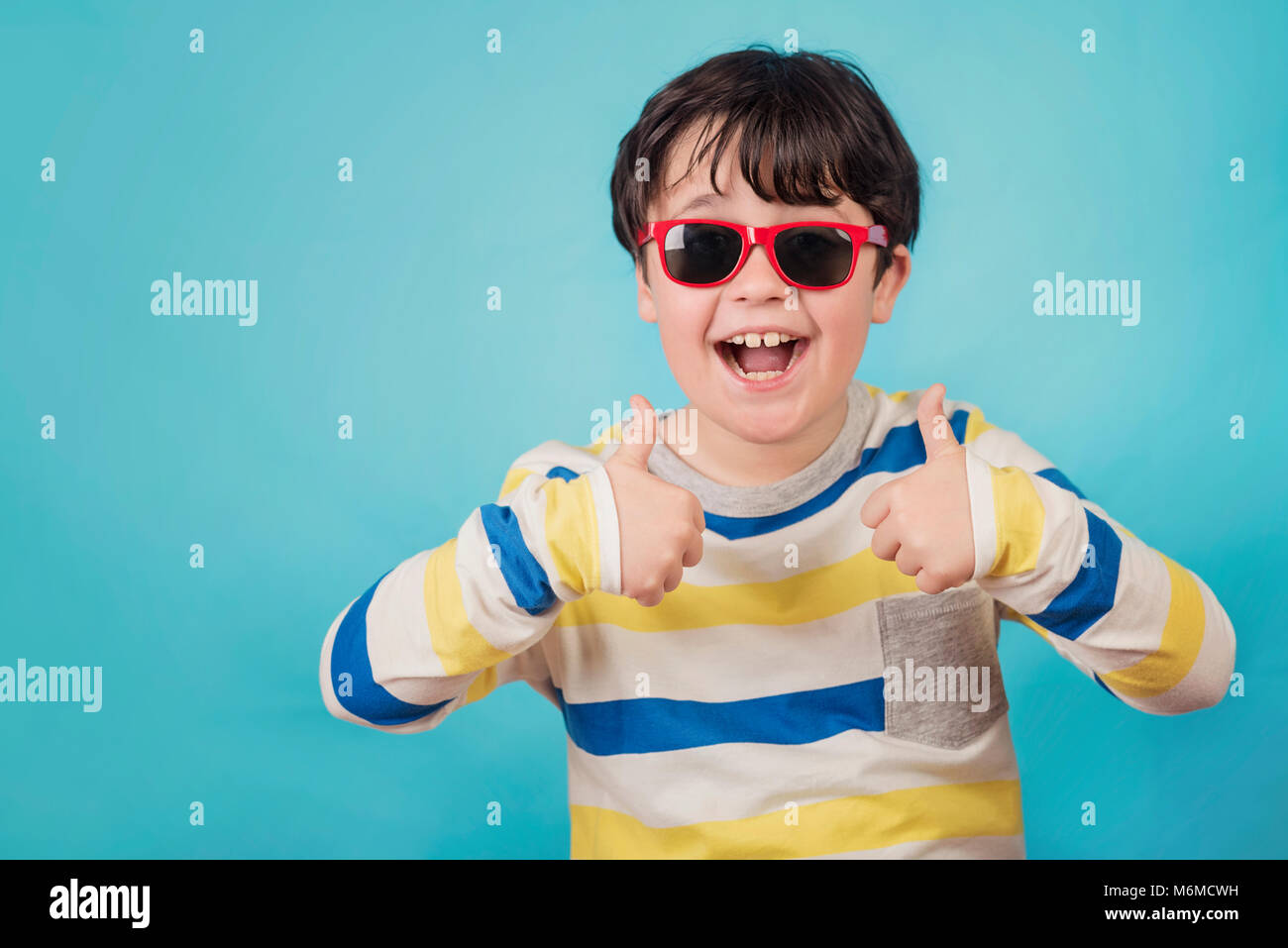 happy boy with sunglasses on blue background Stock Photo