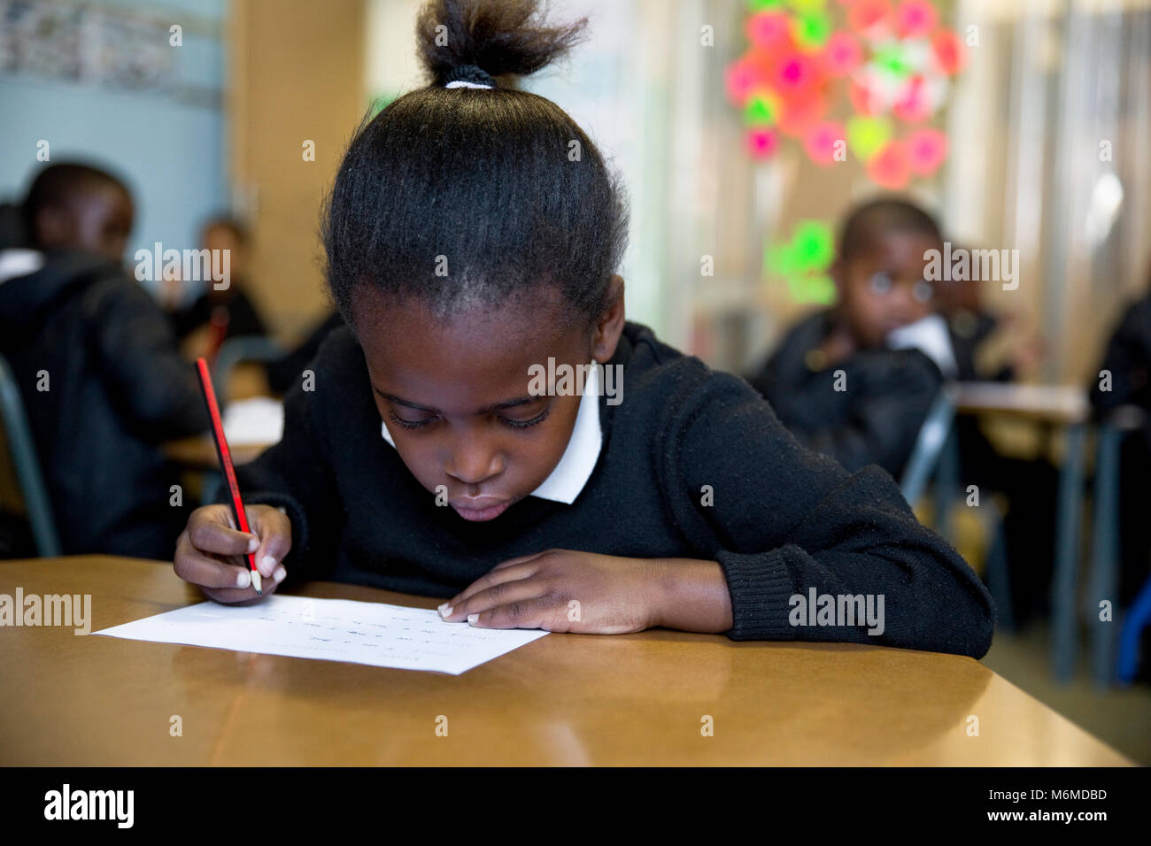 Little girl writing in the classroom Stock Photo