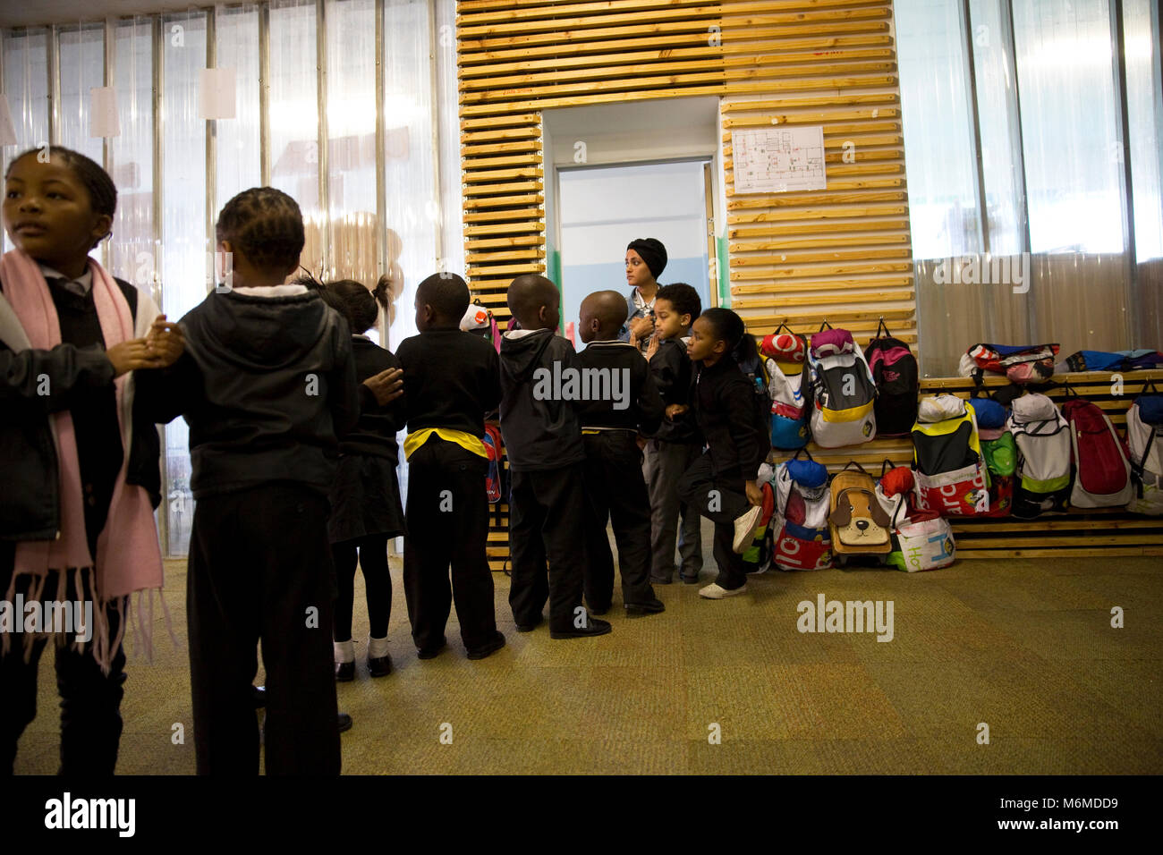 School children standing in a row for teacher to enter the classroom Stock Photo