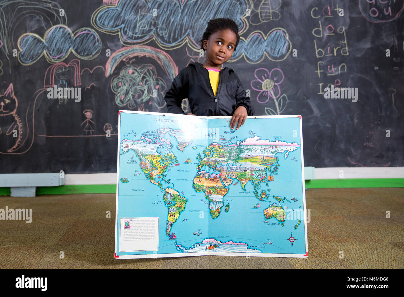 School girl holding a map of the world Stock Photo