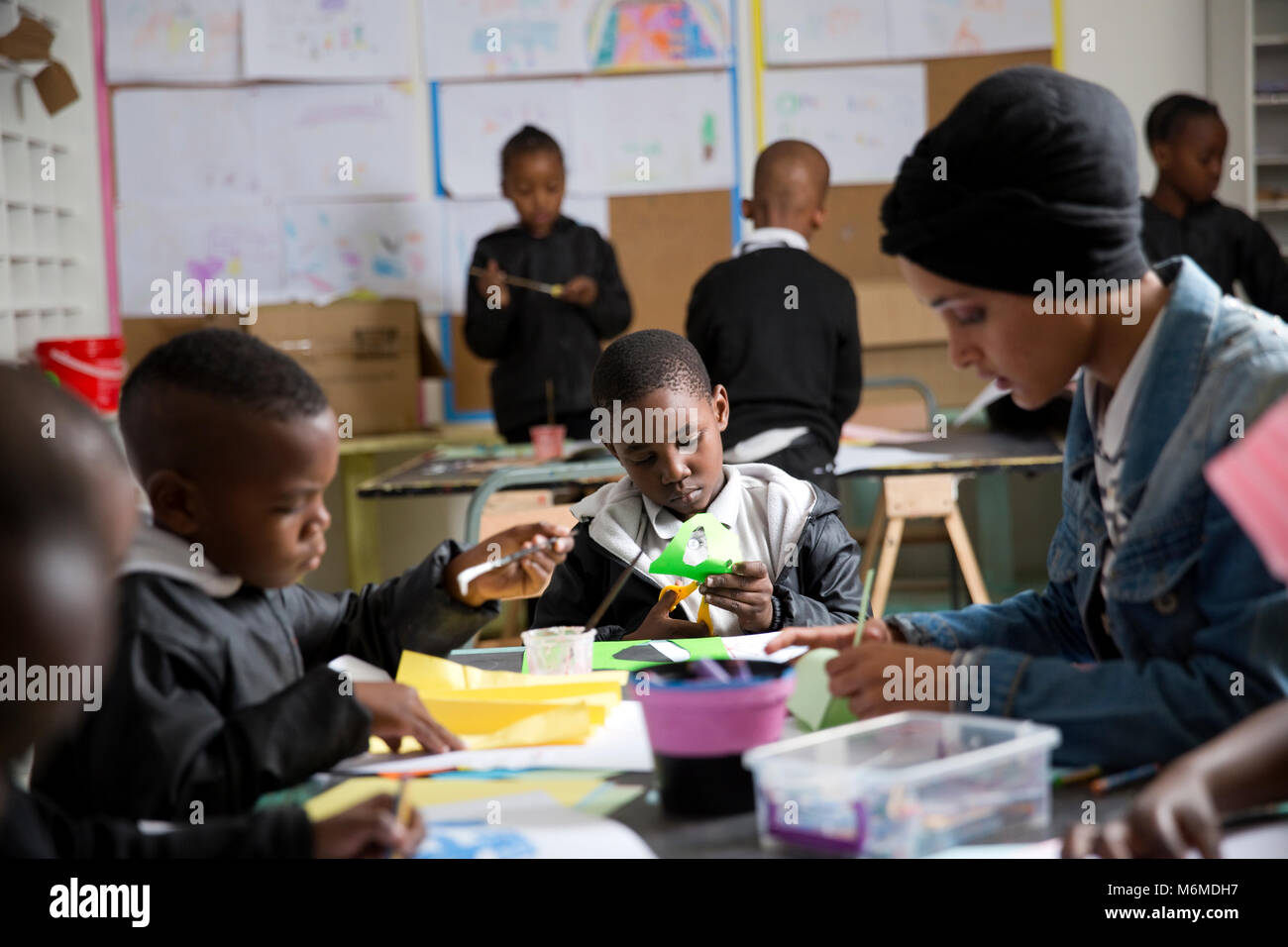 Teacher and kids doing arts and crafts in class Stock Photo