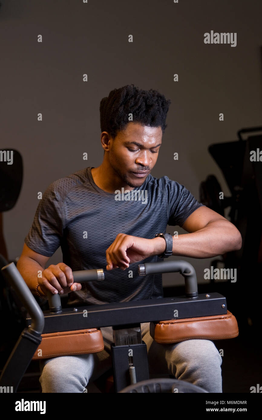 African man looking at smart watch in gymnasium Stock Photo