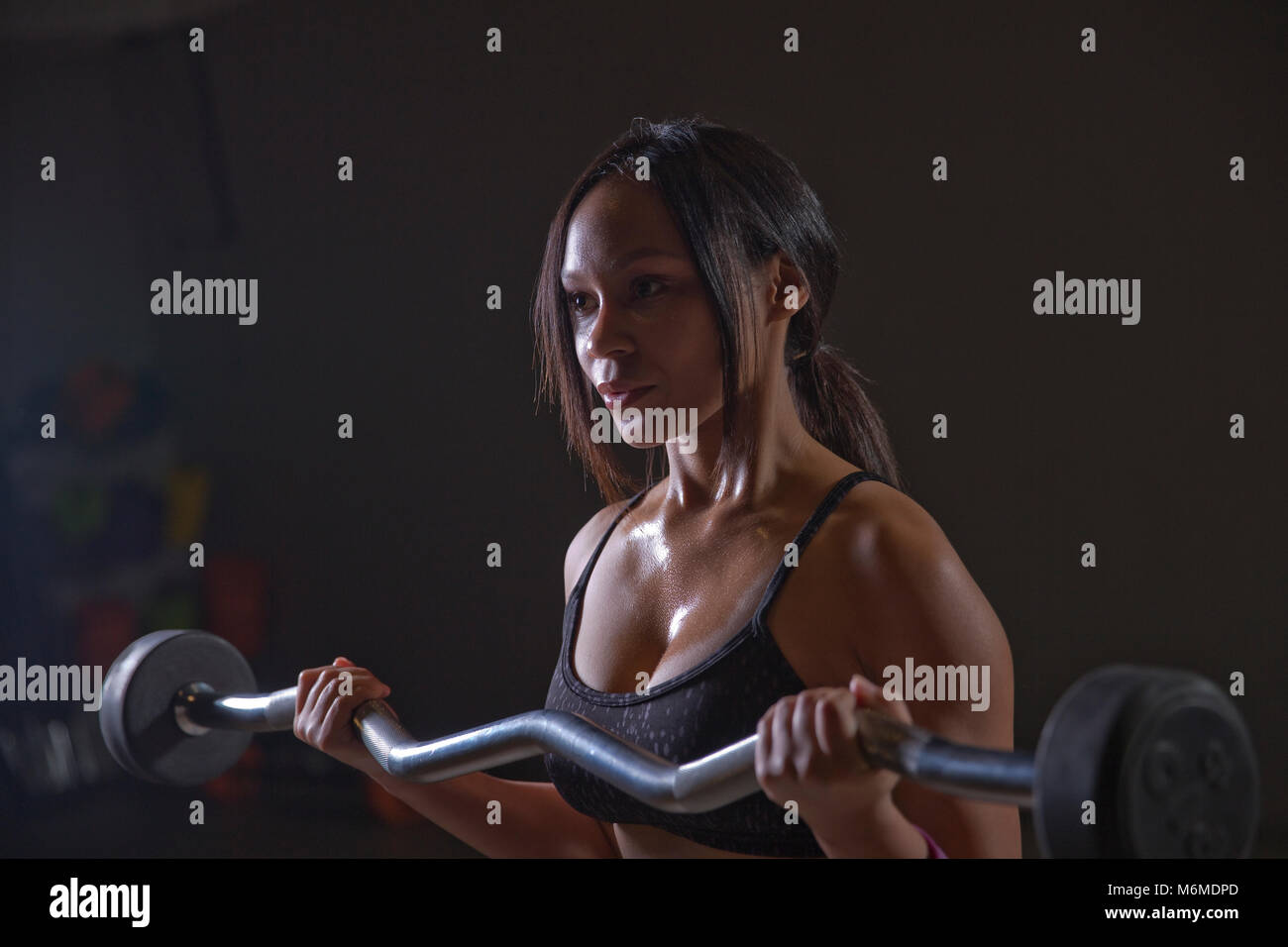 Mixed race athlete lifting weights in gym Stock Photo