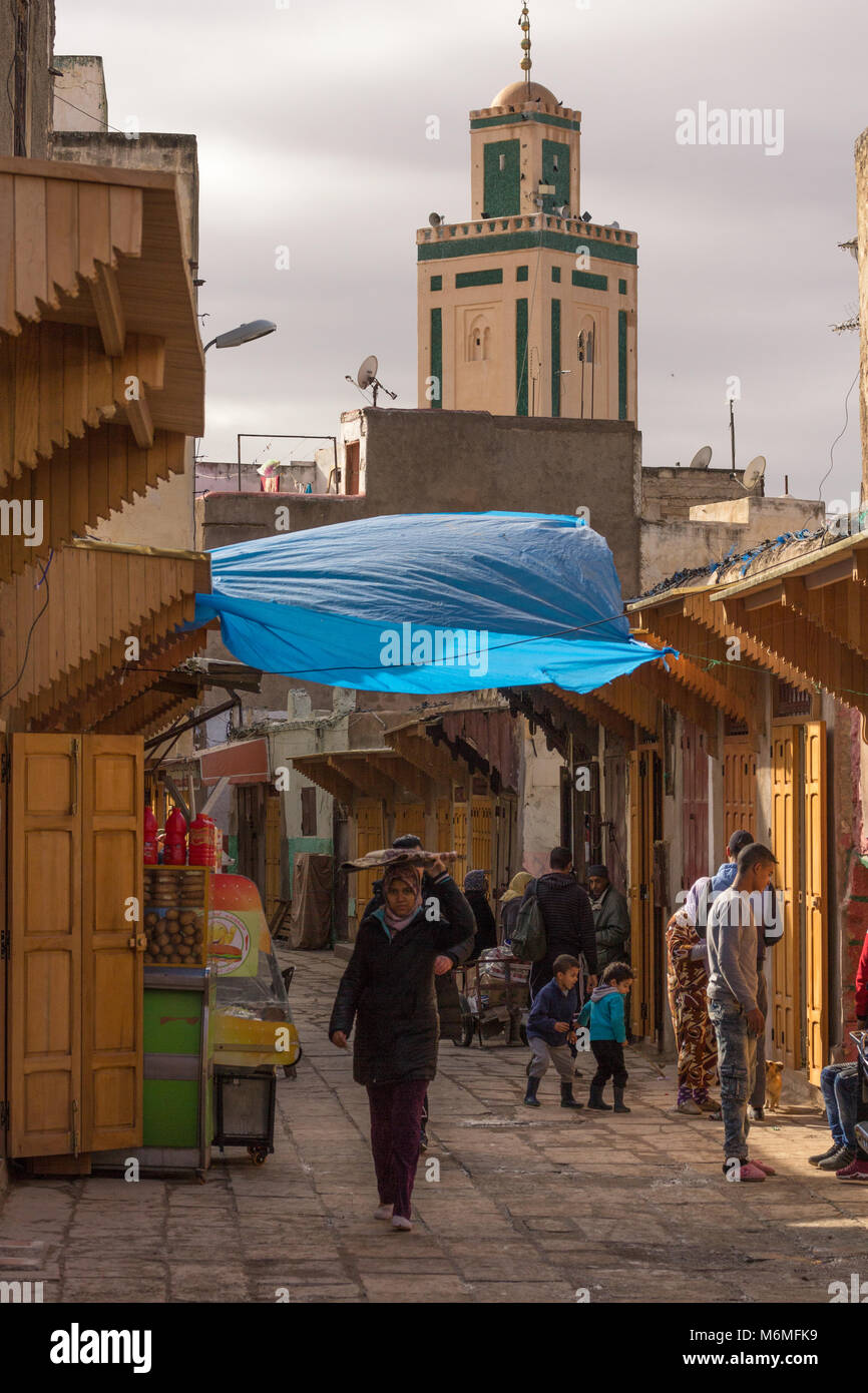 A street scene in the Moulay Abdallah Quarter of Fes el-Jedid, Fes, Morocco, showing the mosque in the background Stock Photo