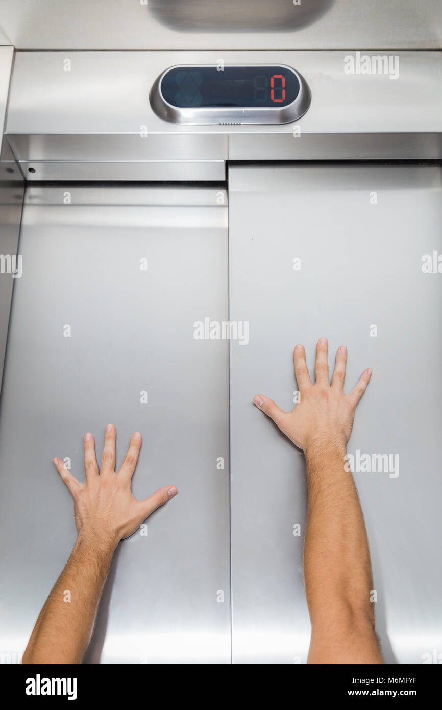 Man hands try to stop and prevent closing elevator door Stock Photo Alamy