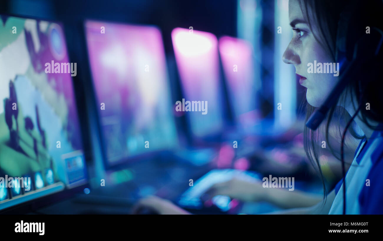 Progamer Girl Playing in MMORPG/ Strategy Video Game and Participating in Online Cyber Games Tournament or Playing in Internet Cafe. Stock Photo