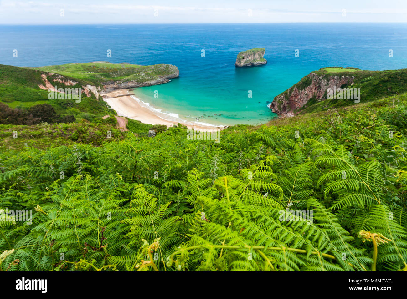 Ballota beach with the islet Castro, Llanes, Asturias , Spain Stock