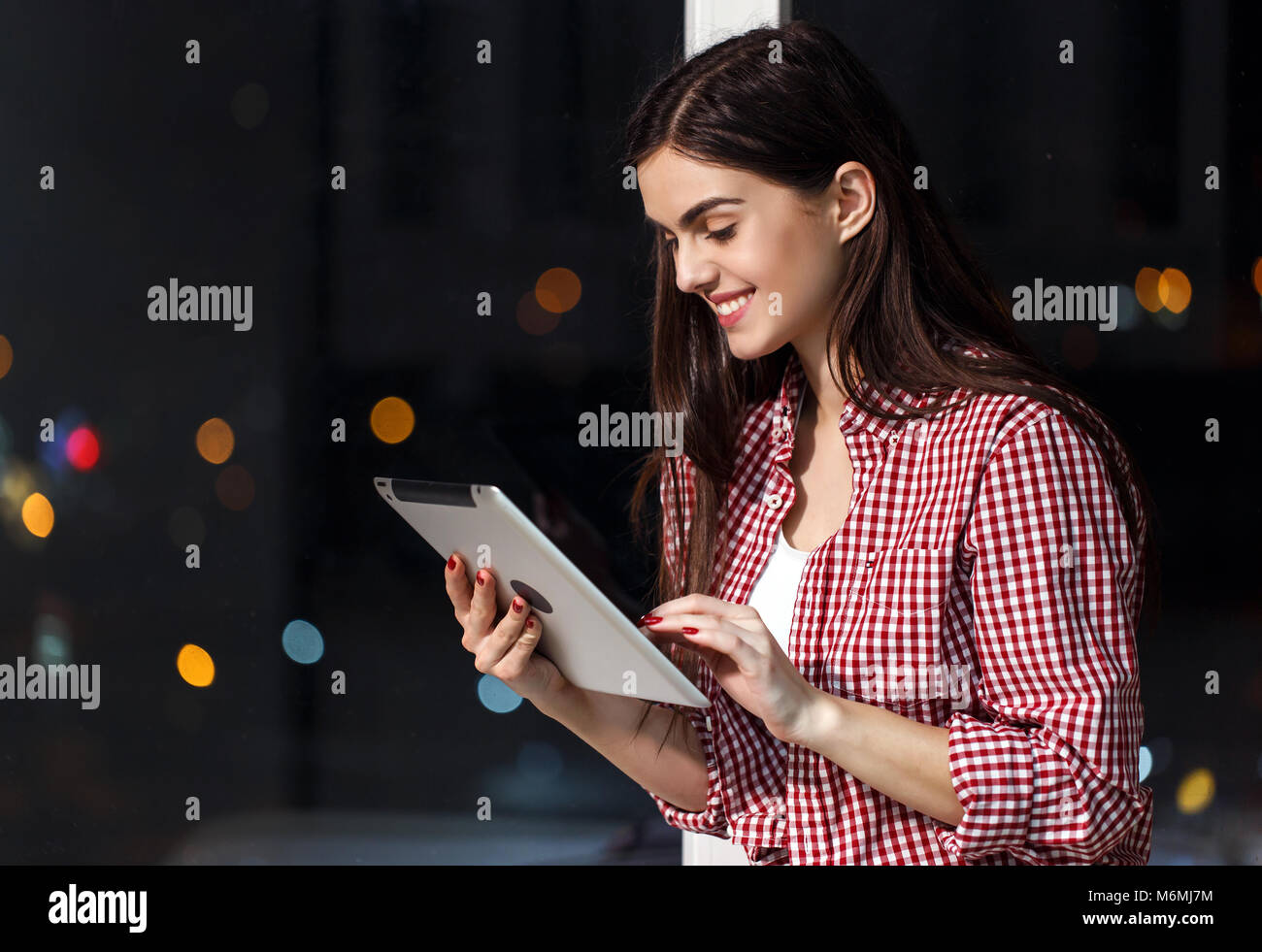 Girl with Tablet on Windowsill Stock Photo