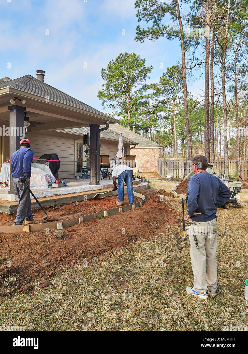 Construction workers at a residential site working on a patio for the home or house in Pike Road Alabama, USA. Stock Photo