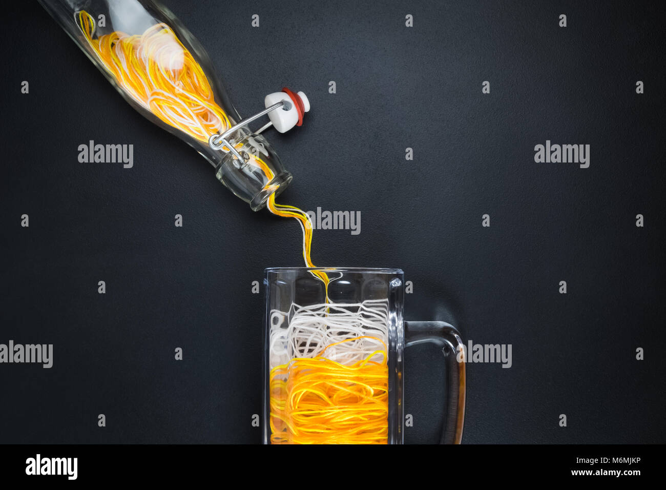 Flat lay of pouring yellow and white threads in form of beer from