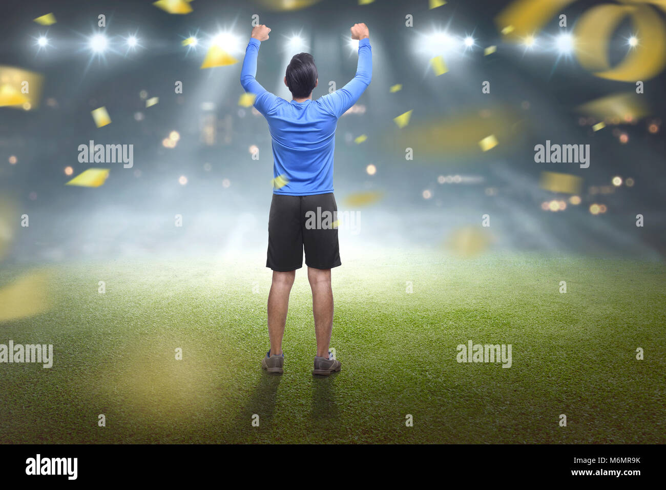 Back view of asian man celebrating his victory with confetti background Stock Photo