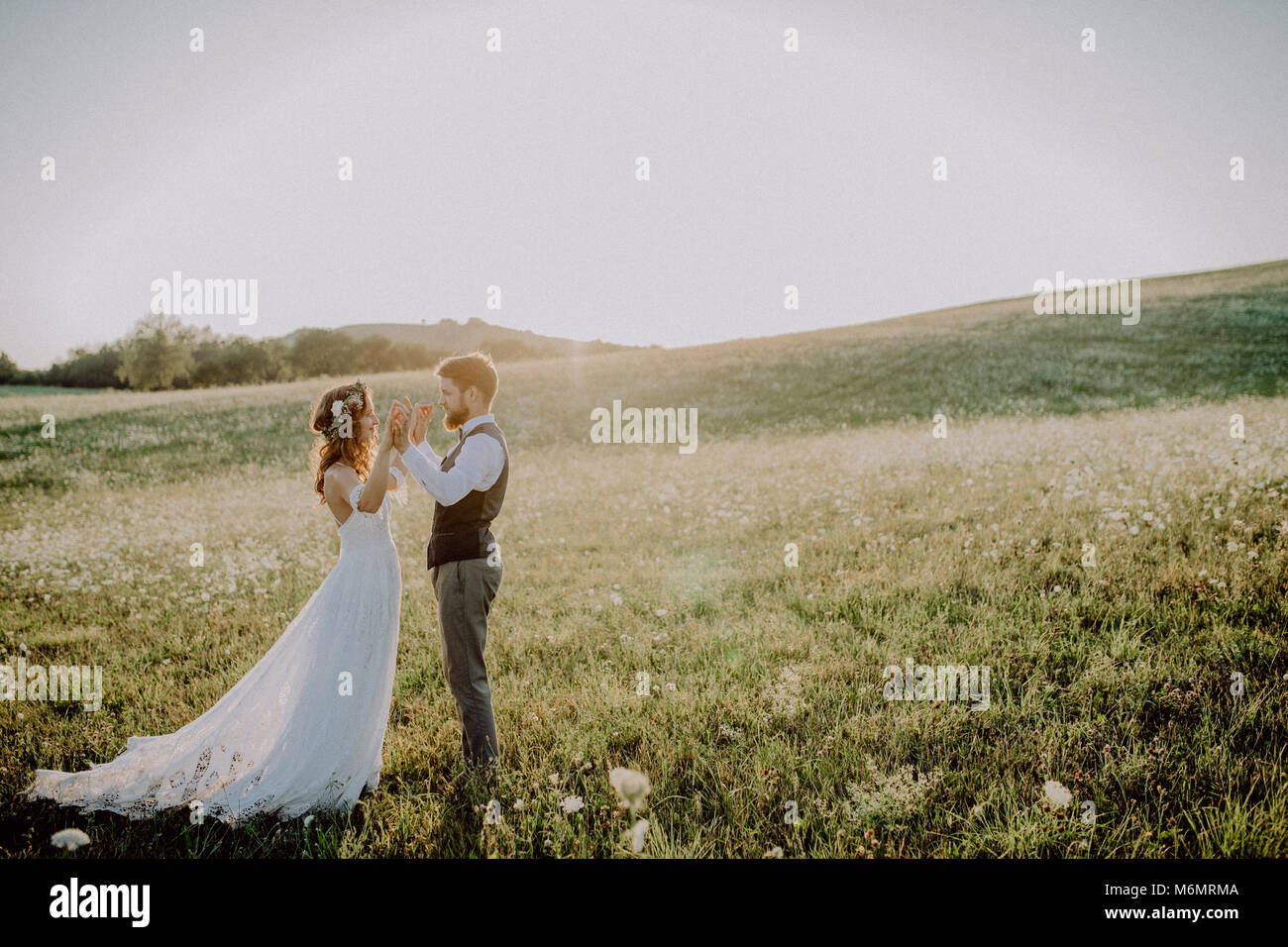 Beautiful bride and groom at sunset in green nature Stock Photo - Alamy