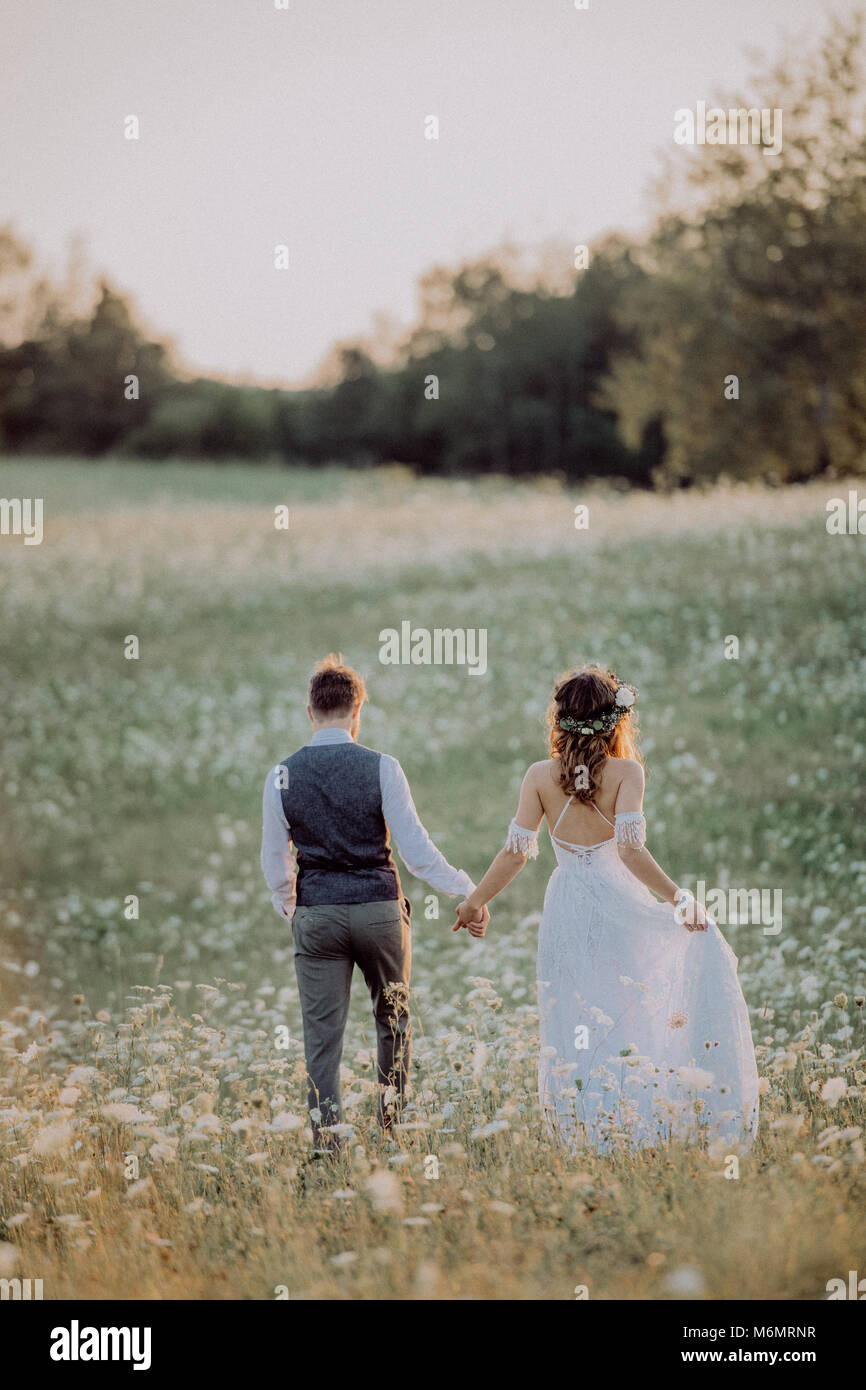 Beautiful bride and groom at sunset in green nature Stock Photo - Alamy