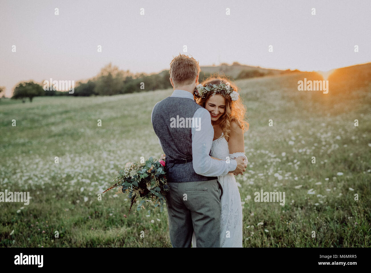 Beautiful bride and groom at sunset in green nature Stock Photo - Alamy
