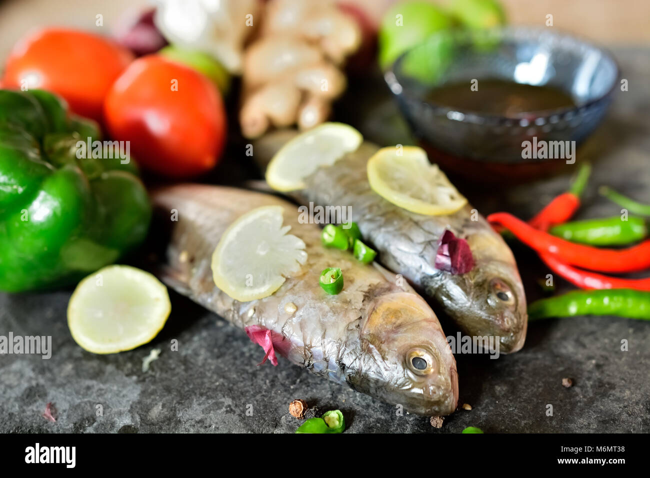 Raw fish on table for cooking Stock Photo - Alamy
