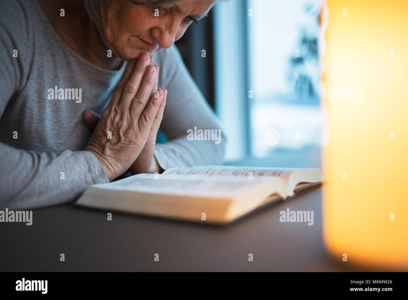 A Senior Woman Praying At Home Stock Photo Alamy