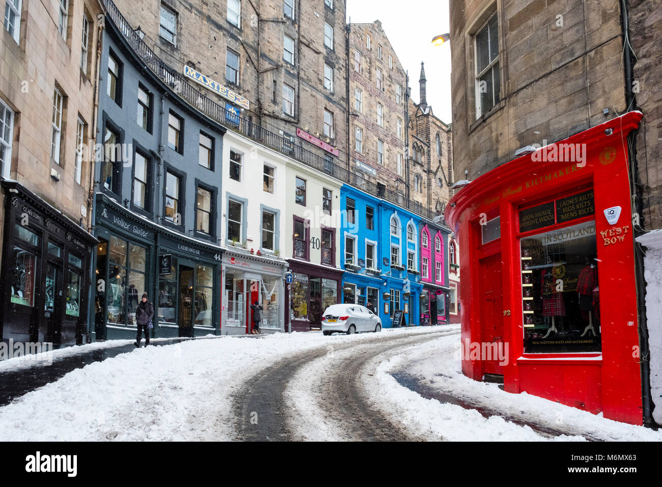 View of colourful shop fronts historic Victoria Street in Edinburgh Old Town after heavy snow, Scotland, United Kingdom Stock Photo