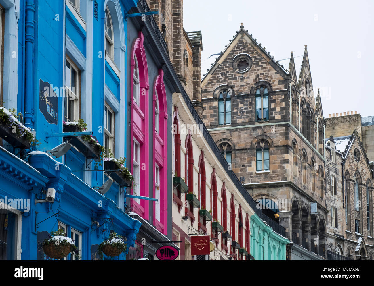 View of colourful shop fronts historic Victoria Street in Edinburgh Old Town after heavy snow, Scotland, United Kingdom Stock Photo