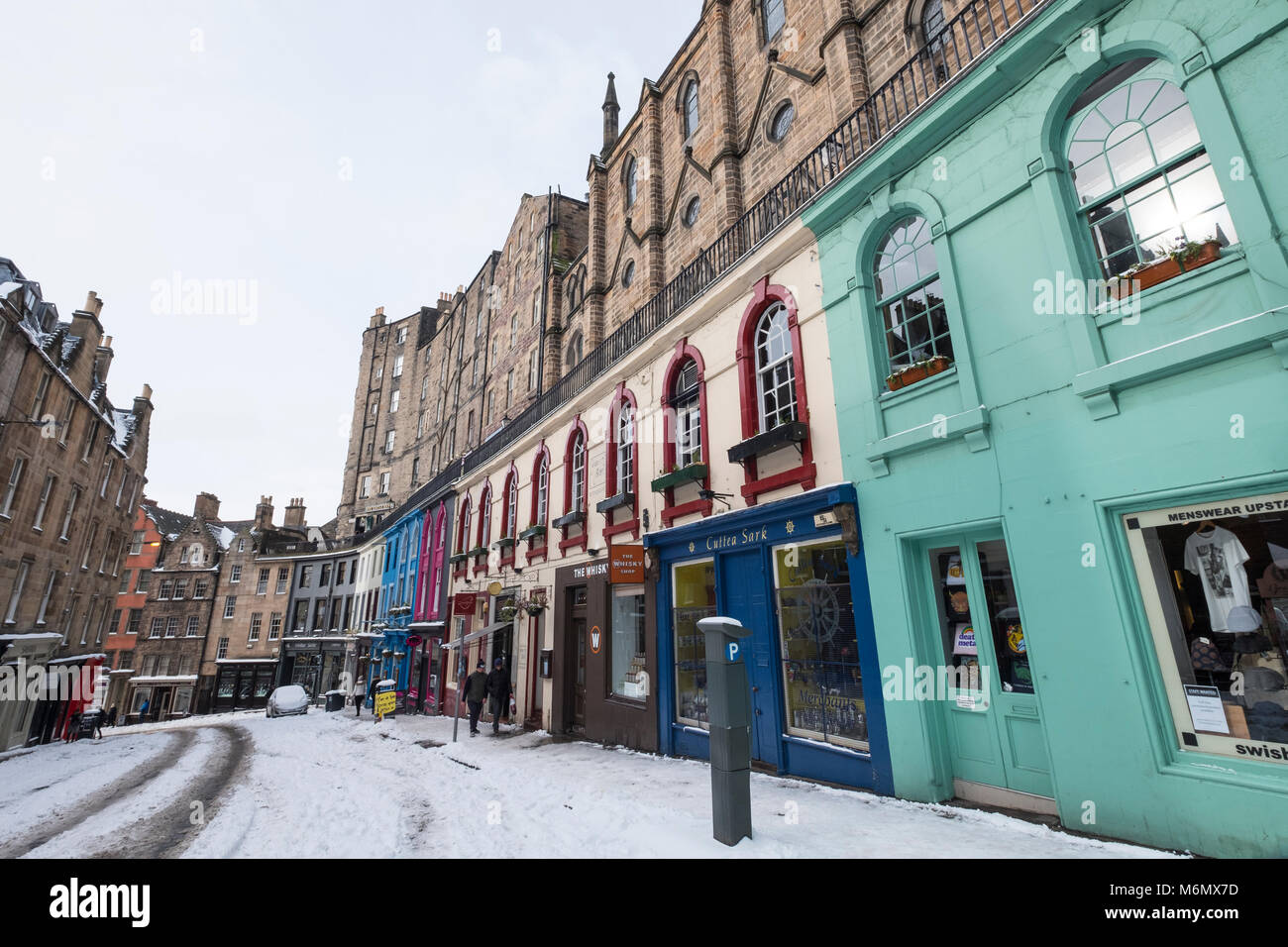 View of colourful shop fronts on historic Victoria Street in Edinburgh Old Town after heavy snow, Scotland, United Kingdom Stock Photo