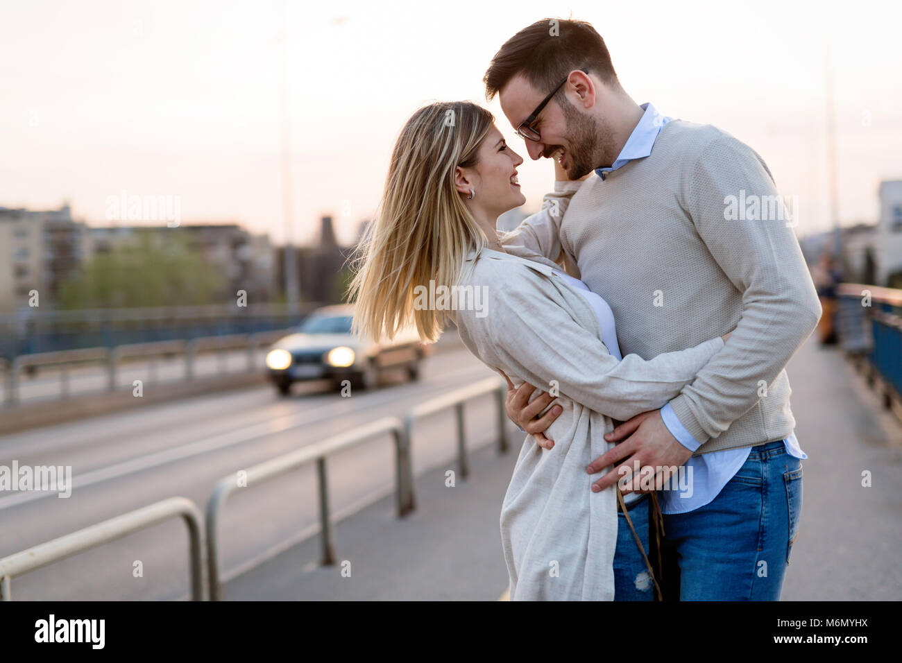 Couple kissing dating on bridge Stock Photo - Alamy