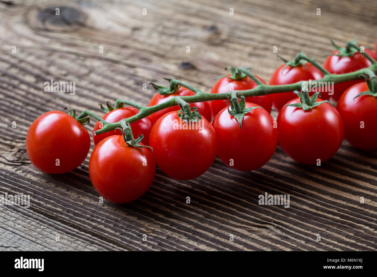 Fresh cherry tomatoes on a brown background. Bunch of fresh cherry ...