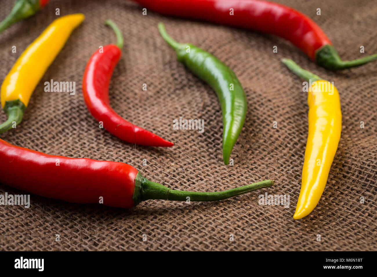 Fresh chili peppers - yellow, green and red chili pepper on brown ...