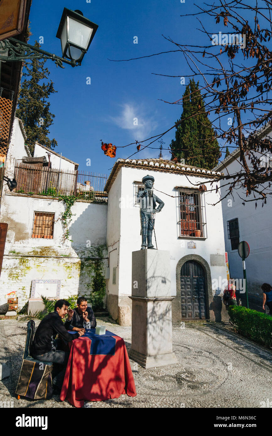 Granada, Andalusia, Spain. Two young men sit at an outdoors cafe in the junction of the Unesco listed Albaicin and Sacromonte districts. Stock Photo