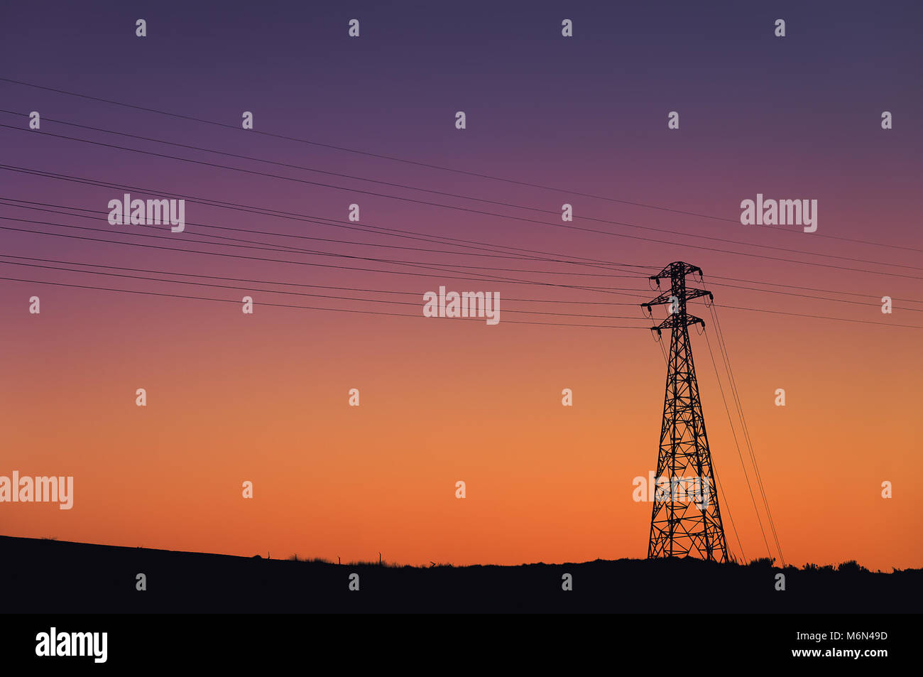 High voltage transmission tower silhouette with beautiful sunset sky ...