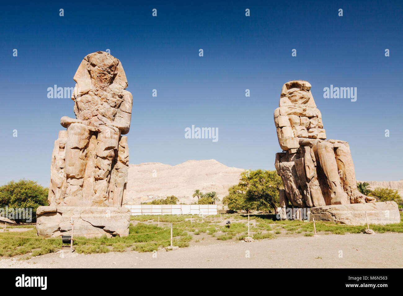 Luxor, Egypt. Colossi of Memnon,  two massive stone statues of the Pharaoh Amenhotep III, who reigned in Egypt during the Dynasty XVIII. Stock Photo