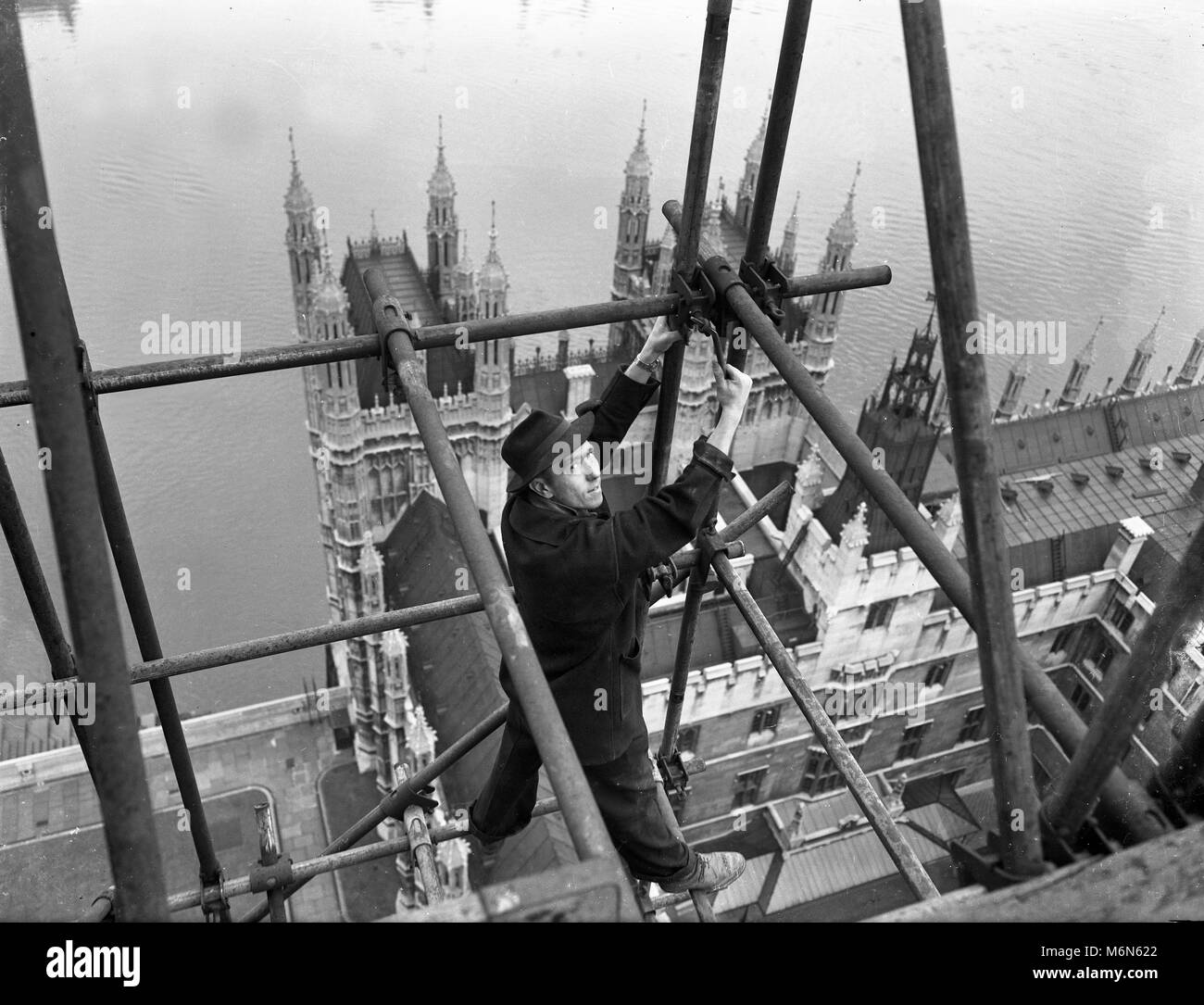 Construction worker erecting scaffolding on the 'Big Ben' clock tower on the Houses of Parliament also called Palace of Westminster in 1948. Pre health and safety at work regulations. Stock Photo