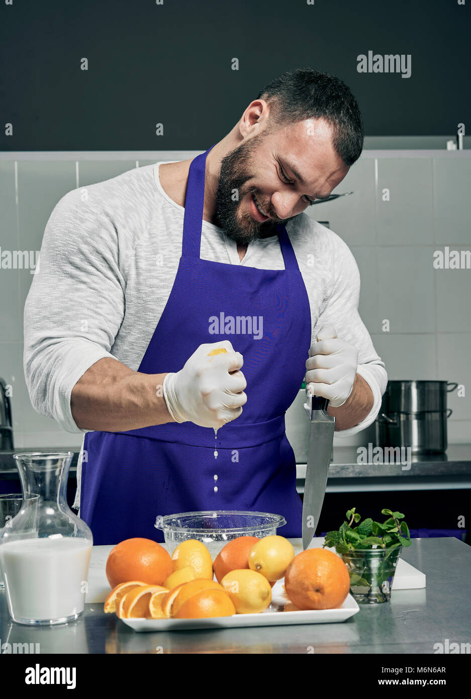 Strong Cheff strong bearded chef prepares salad and juice Stock Photo - Alamy