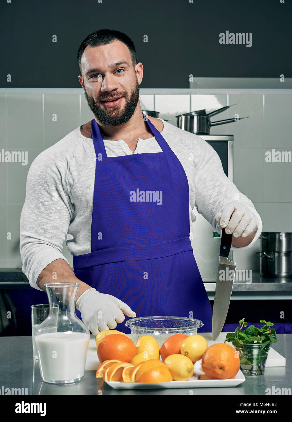 Strong Cheff strong bearded chef prepares salad and juice Stock Photo - Alamy