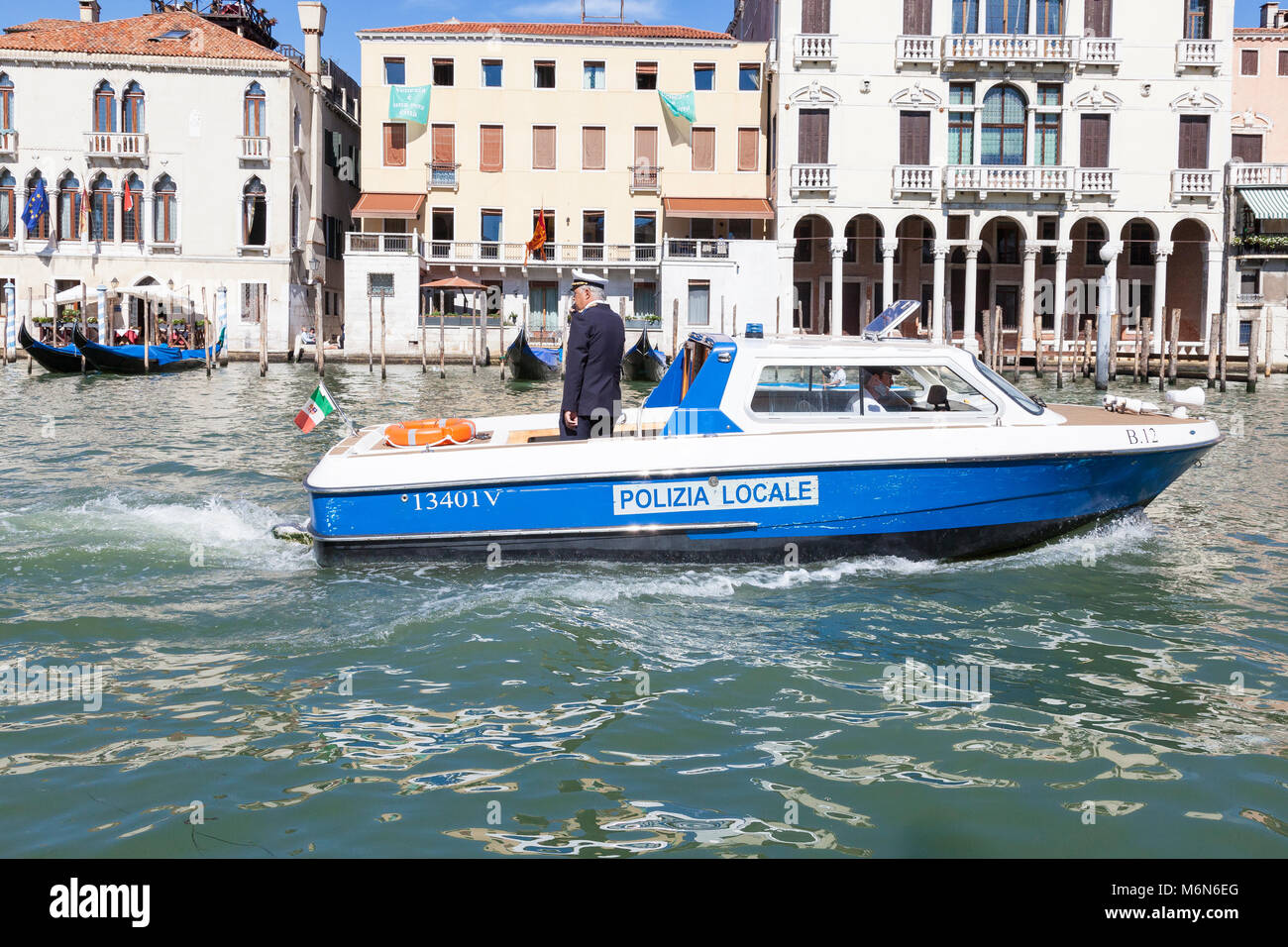Polizia Locale boat on the Grand Canal, Venice, Veneto, Italy with two local Italian police officers on patrol in Cannaregio Stock Photo