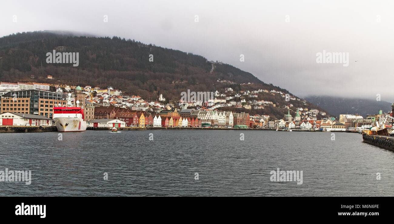 Port in Bergen. Look at the bryggen direction. Buildings on the hill. overcast weather. Stock Photo