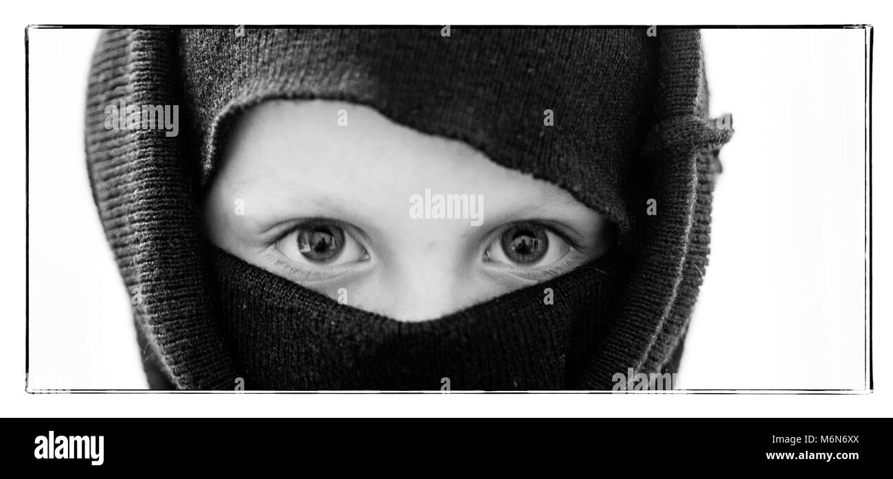 A little Caucasian boy wearing a ninja mask Stock Photo