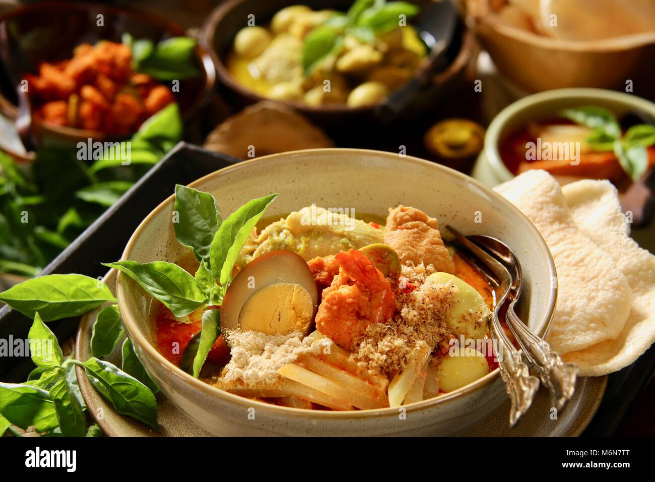 Lontong Cap Go Meh. The Javanese-Peranakan Rice Cake Soup with Chicken Curry, Chayote Squash Curry, Soy Egg, Shrimp Stew, Ground Soybean and Crackers. Stock Photo