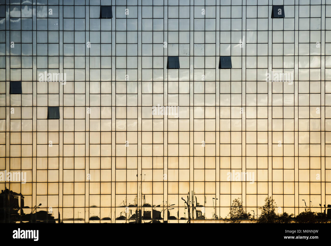 Modern office building wall made of glass with open windows and reflections, abstract background photo texture Stock Photo
